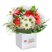 Joyful and inviting, this Upton Park bouquet gathers all the exuberance of a fresh new day. Frilled coral and scarlet carnations cluster together with warmth and vibrancy, while snowy daisies with yellow-green centers lend a sparkling innocence, reminiscent of wildflowers beside the local allotments. Wisps of white baby's breath create pockets of softness and air throughout the bouquet, and hints of purple-tinged buds tucked into the left side bring gentle intrigue, as if promising tomorrow's blooms. Encasing this lively harmony, broad arcs of gleaming green leaves form a natural, protective collar-a nod to the thriving gardens found in Upton Park's residential streets. The bouquet fills a sleek white paper gift bag, complete with ribbon handles for easy carrying, the whole ensemble isolated on a pure background to highlight freshness and colour. Expertly arranged, the flowers reveal the artistry of a local florist with deep community roots. Whether destined as a birthday delight, a heartfelt thank you, or a simple way to add beauty to someone's day, this bouquet is a heartfelt tribute to both Upton Park's generous spirit and the timeless joy of sharing flowers.